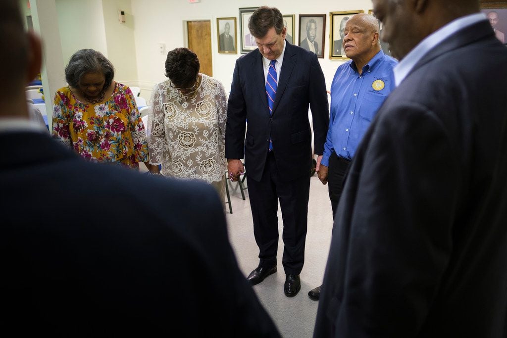 Dallas Mayor Mike Rawlings (center) holds hand is Patria Henderson Meshack (second from left) as he prays with members at St. Paul AME Church before services on Sunday, May 19, 2019, in Dallas. (Smiley N. Pool/The Dallas Morning News) 