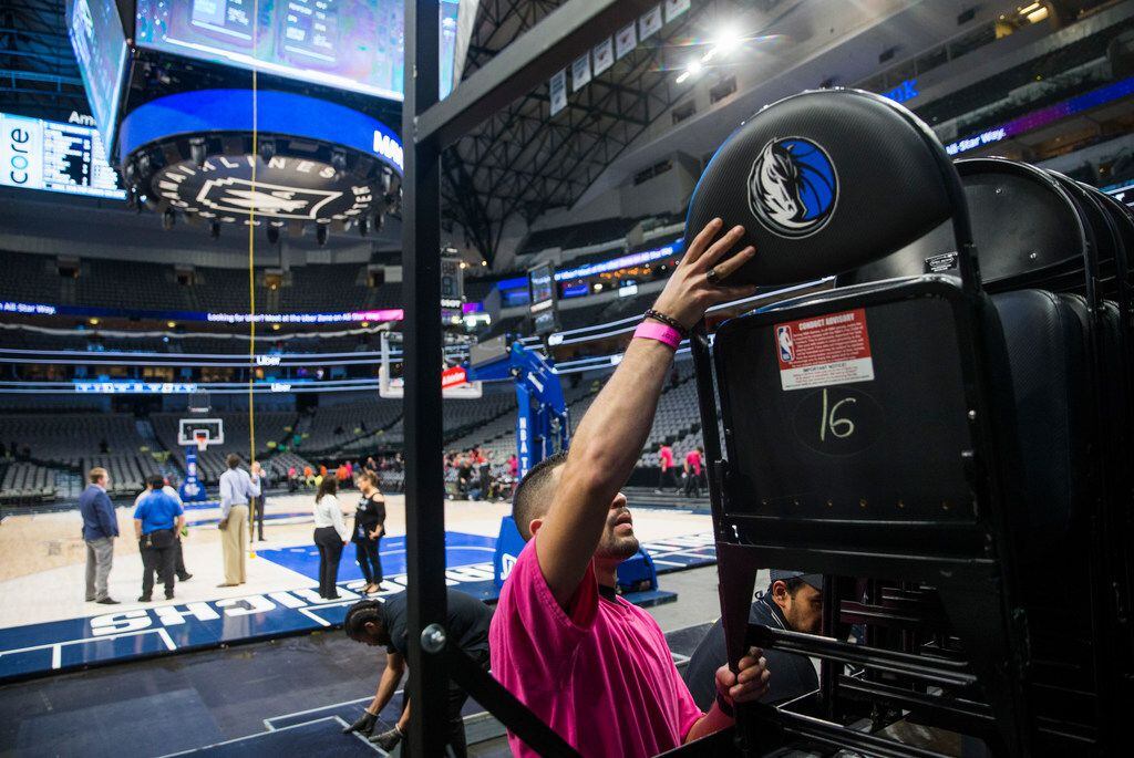 Crews remove chairs from the court after the Dallas Mavericks beat the Denver Nuggets 113-97...