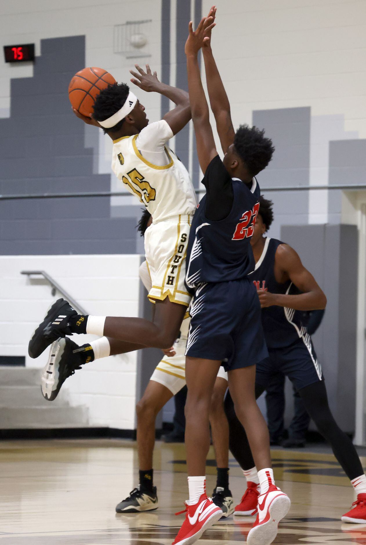 South Oak Cliff's Devion Wilson (15), left, shoots a jumper against the defense of Kimball's...