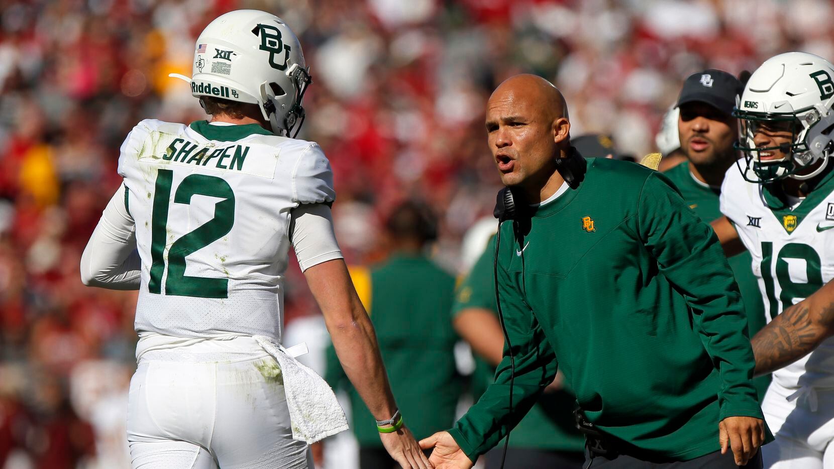 Baylor coach Dave Aranda, right, slaps the hand of quarterback Blake Shapen in the first...