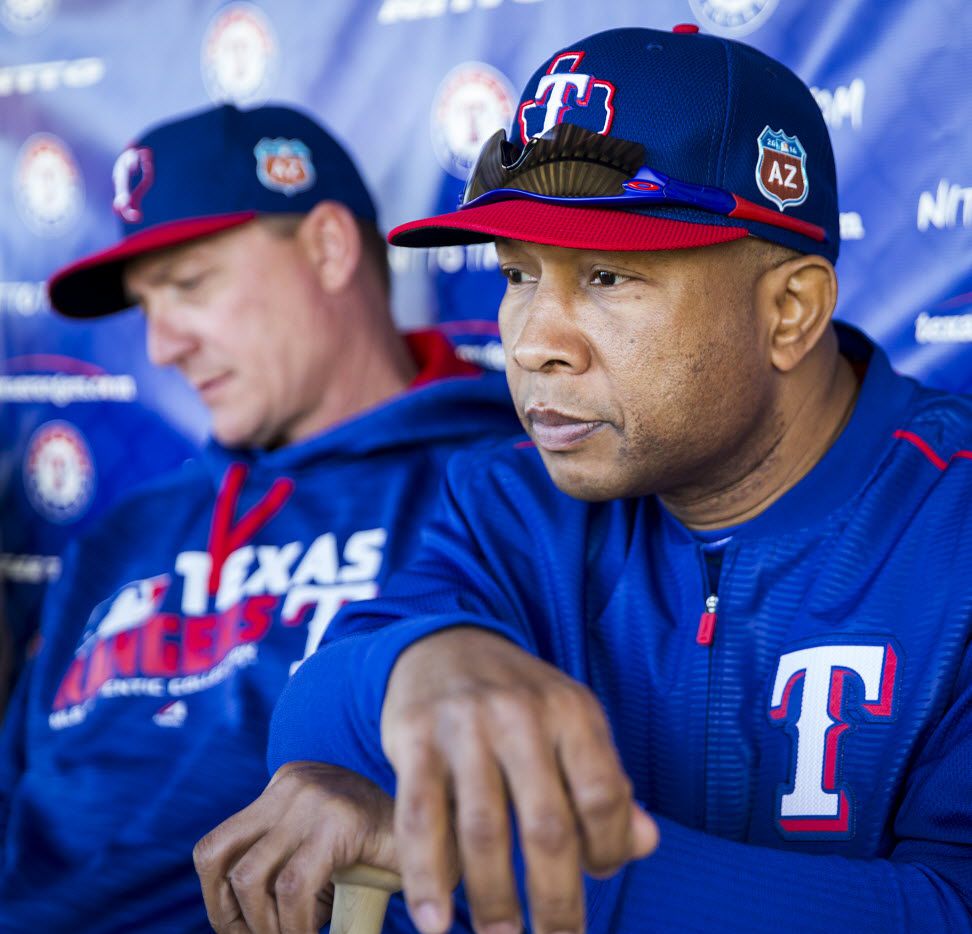 Texas Rangers third base coach Tony Beasley sits in a dugout with manager Jeff Banister...