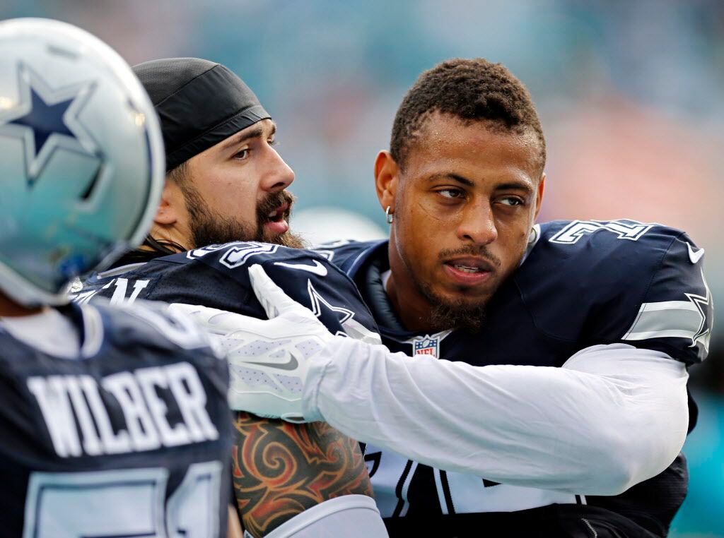 Cowboys defensive end Greg Hardy (right) hugs defensive tackle Nick Hayden before their game...