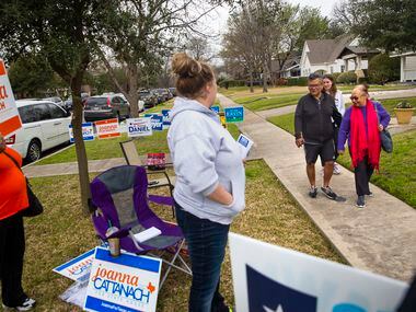 A group of voters (names withheld for privacy) pass by campaign volunteers while on their...