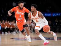 Texas' Tyrese Hunter (4) drives against Illinois' Jayden Epps (3) during the first half of...