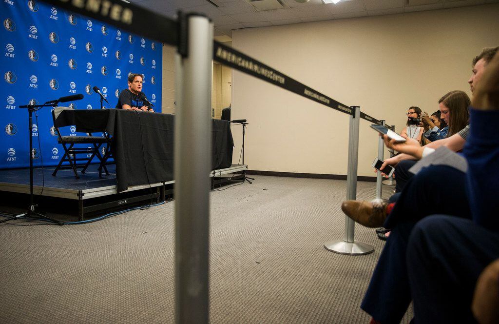 Dallas Mavericks owner Mark Cuban speaks to reporters from behind a barrier that is usually...