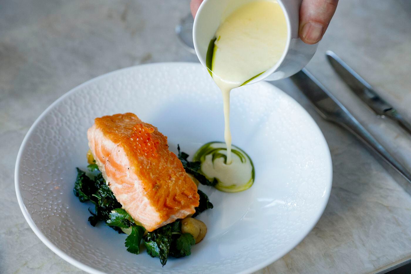 Roasted salmon with beurre blanc and kombu oil poured table side at Mirador restaurant in...