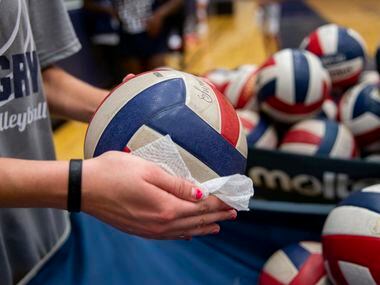 Volleyballs are sanitized after Flower Mound High School volleyball players finish practice...