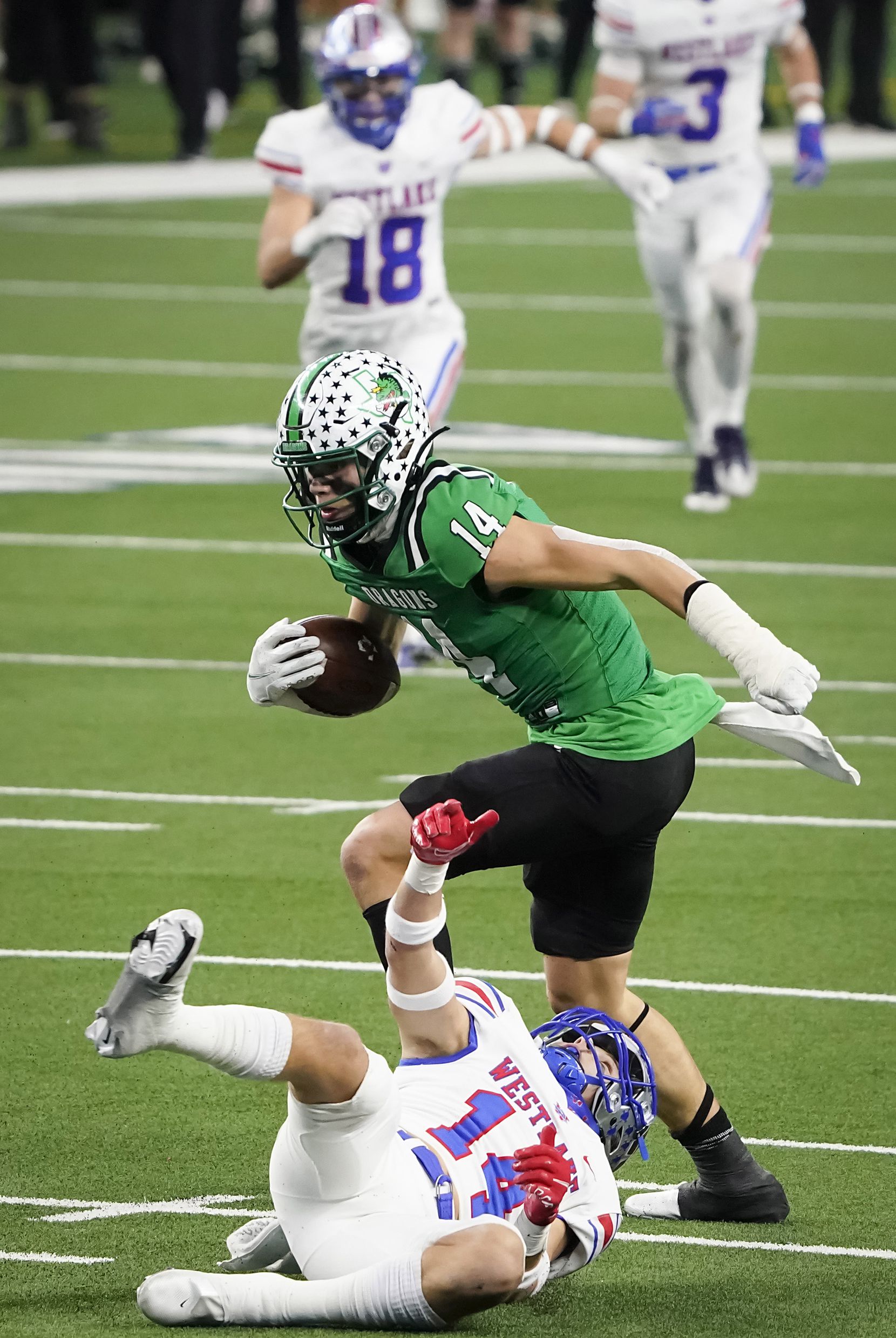 Southlake Carroll wide receiver Brady Boyd (14) break the tackles of Austin Westlake defensive back Michael Taaffe (14) on a 49-yard touchdown play during the first quarter of the Class 6A Division I state football championship game at AT&T Stadium on Saturday, Jan. 16, 2021, in Arlington, Texas.