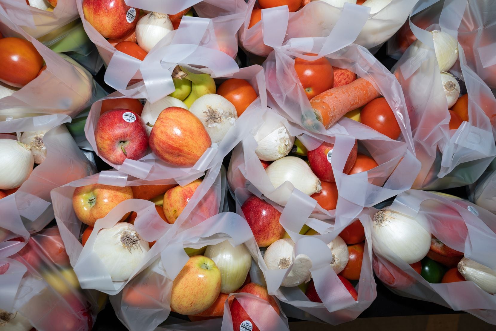Bags of fruit and vegetables were handed to families during a drive-up event offering a...