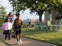 Bria Groom, 5, Erza Garcia (right), 8, and Gysell Garcia walk up to Dallas ISD’s Edna Rowe...