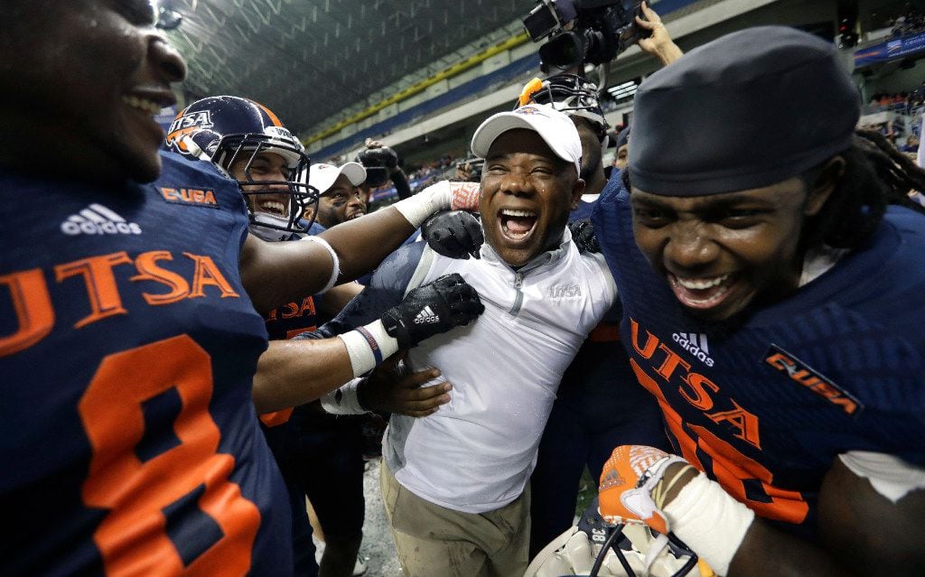 UTSA head coach Frank Wilson, center, and his players celebrate their win over Charlotte in...