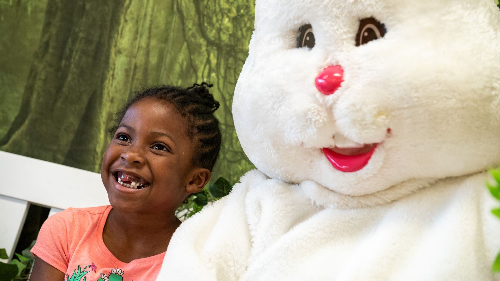 Alissia Dillard, 6, poses for pictures with the Easter Bunny during an Easter celebration at...