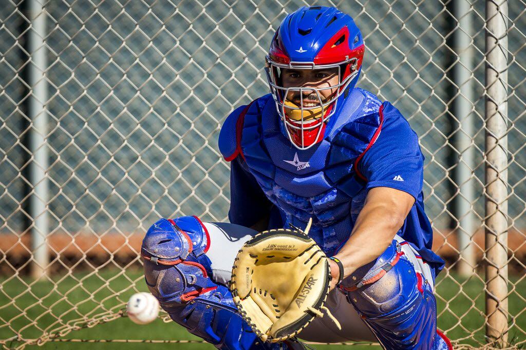 Texas Rangers catcher Robinson Chirinos works on drill for framing low pitches during a...