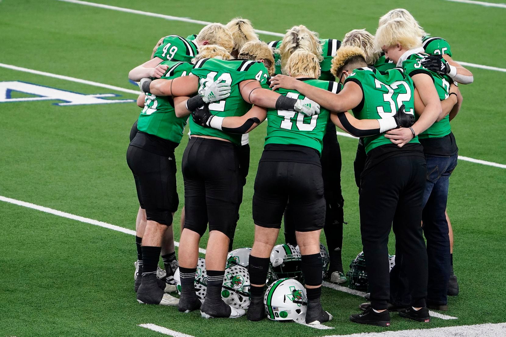 Southlake Carroll players huddle on the field before the Class 6A Division I state football championship game against Austin Westlake at AT&T Stadium on Saturday, Jan. 16, 2021, in Arlington, Texas.