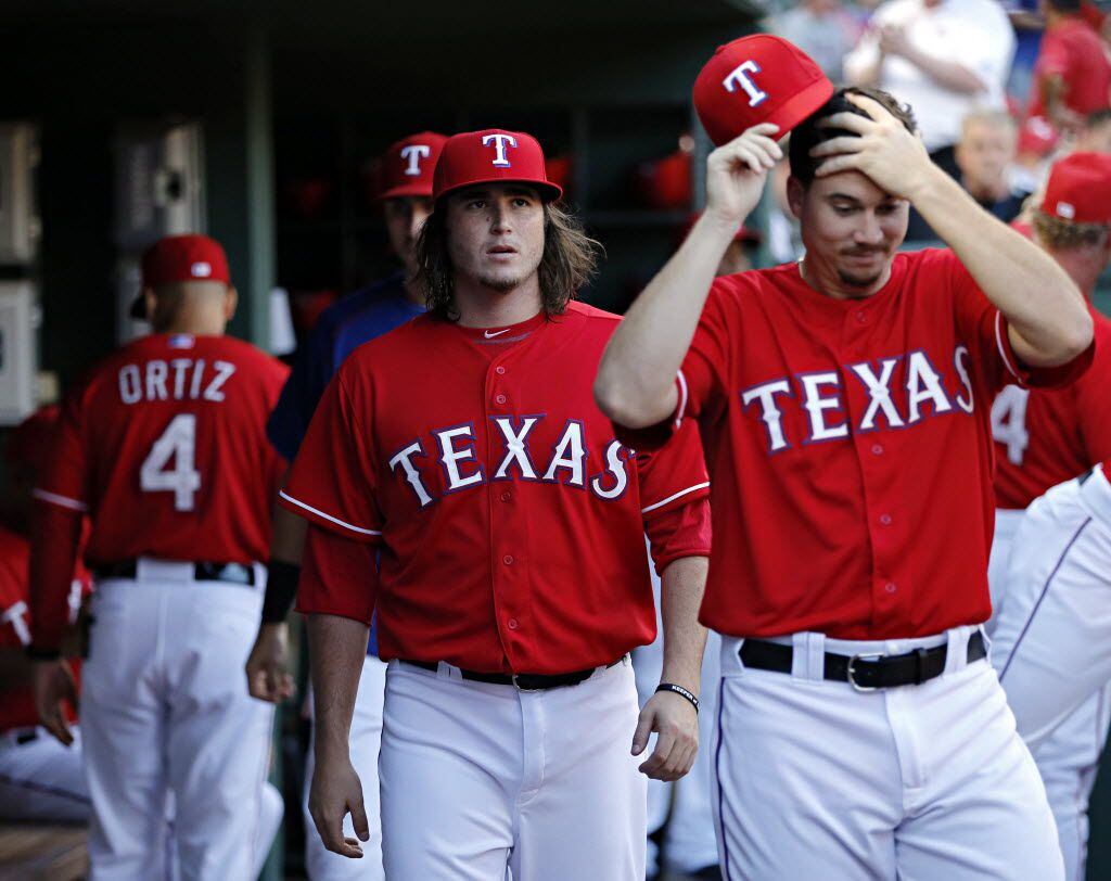Texas Rangers relief pitchers Luke Jackson (center) and Chi Chi Gonzalez roam the dugout...