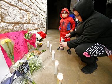 Roxie Murillo lights a candle with her 4-year-old son, Julian Ruiz, at a memorial for...