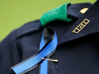 A Dallas Police officer wears a blue ribbon during the Tribute 7/7 memorial event at Dallas...