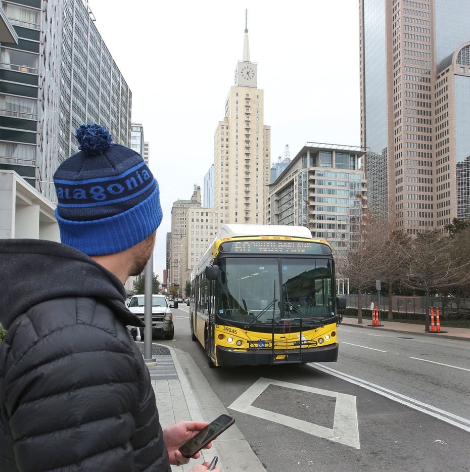 Brendan Meyer catches the bus on Commerce Street in front of The Dallas Morning News office...