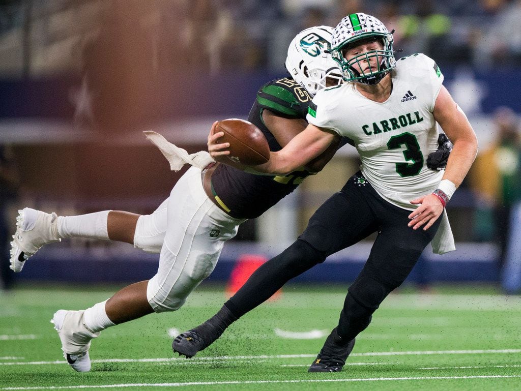 Southlake Carroll quarterback Quinn Ewers (3) holds on to the ball as he's tackled by DeSoto...