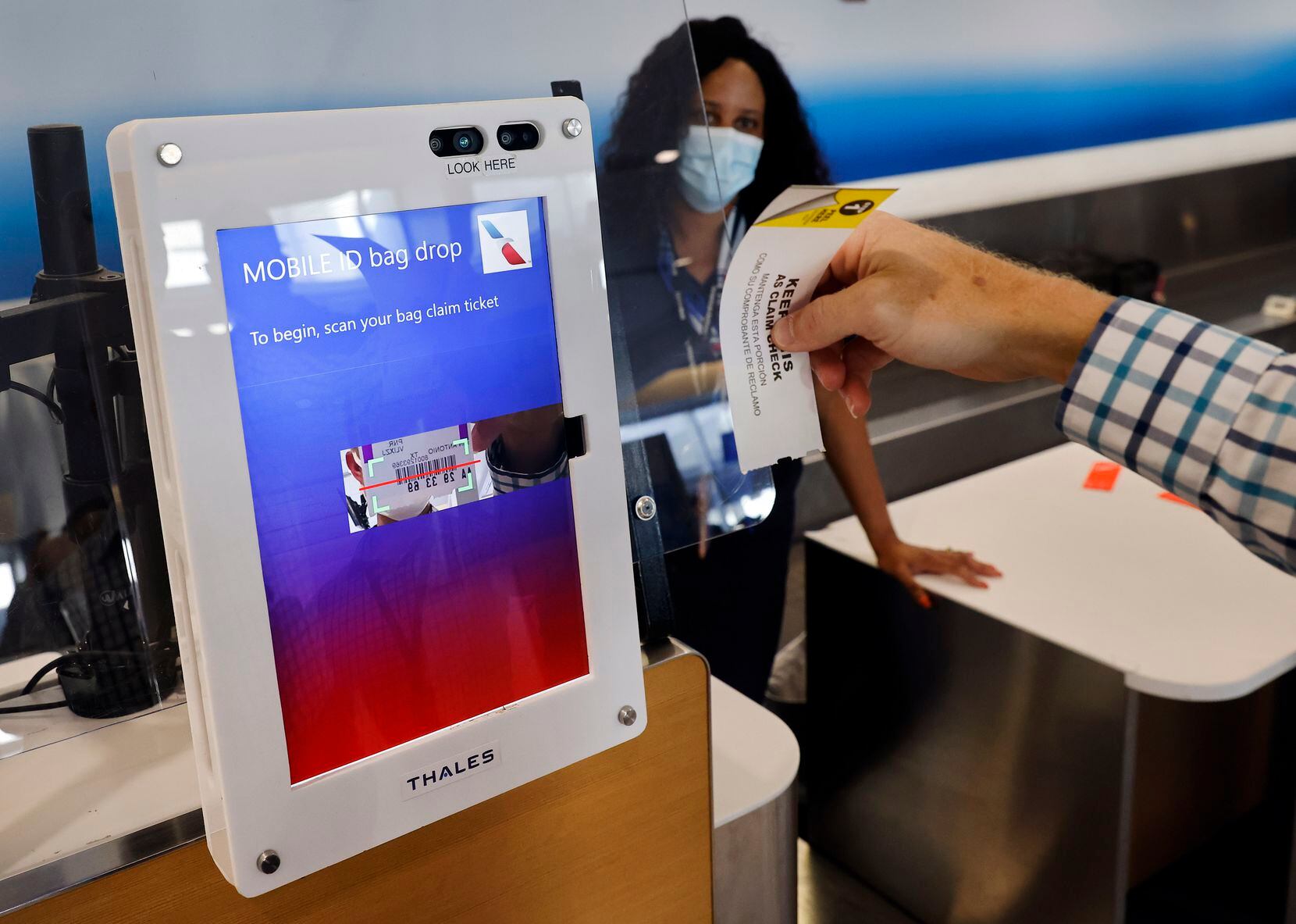 Travis Evenson, an American Airlines customer experience senior project manager, demonstrates how airline passengers use a new mobile ID bag drop, a touchless technology at DFW International Airport.