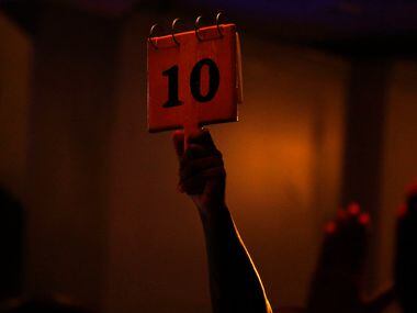 A judge gives a poet a perfect 10 score during a Dallas Poetry Slam open mic. Slam...