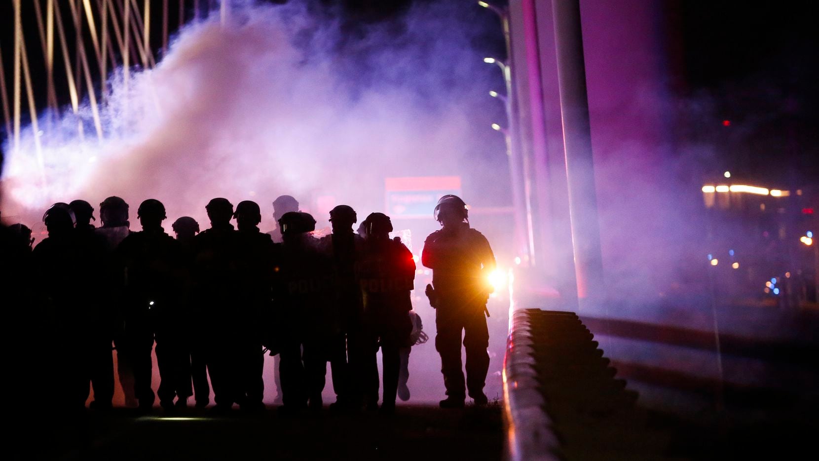 Police deploy crowd control chemical agents as they surround protesters who marched onto the...