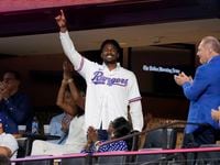 Texas Rangers' Kumar Rocker acknowledges applause from fans after being introduced on the...