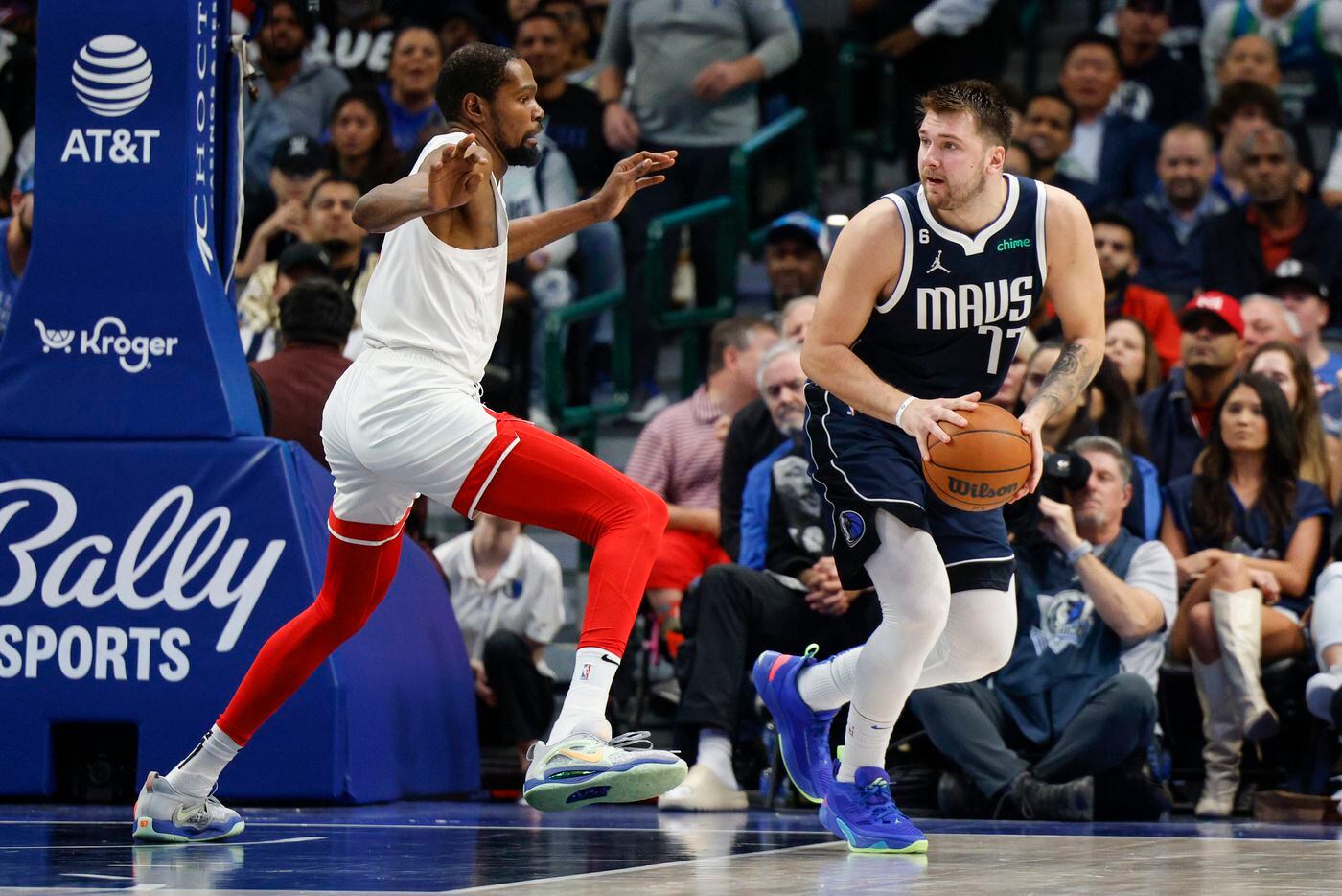 Dallas Mavericks guard Luka Doncic (77) looks to pass alongside Brooklyn Nets forward Kevin...