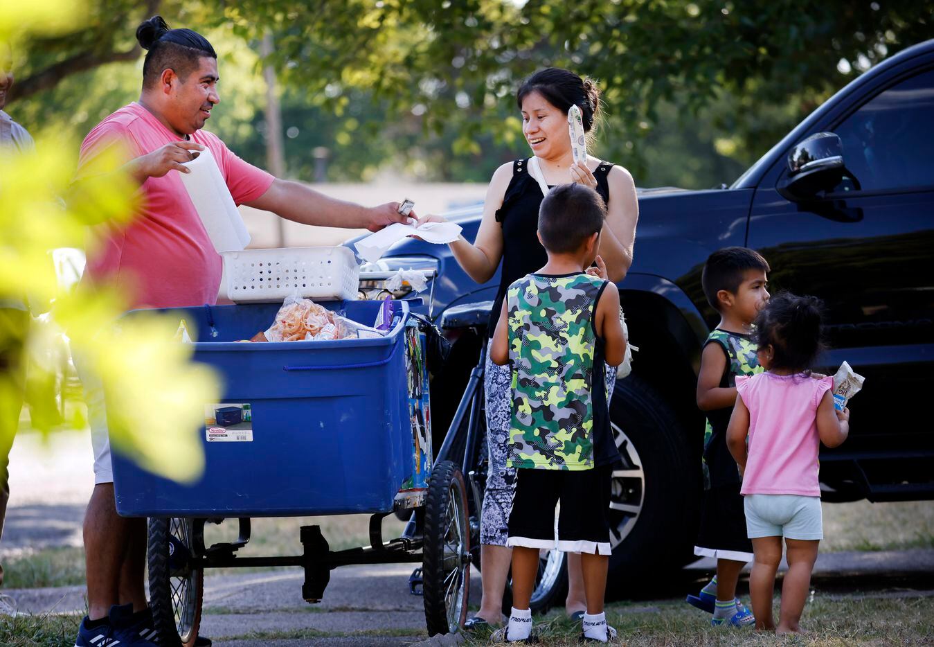 Manuel Maldonado, de 32 años, vende paletas y botanas a una familia en su vecindario de...