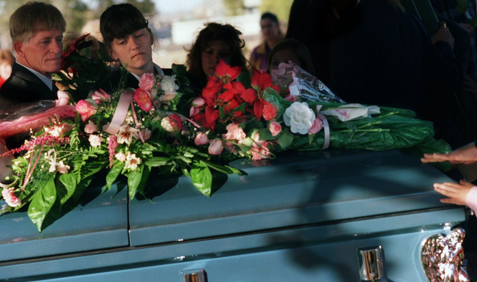 Amber Hagerman's parents lay a rose  on Amber's casket as they leave graveside services on Jan. 20, 1996 in Arlington.