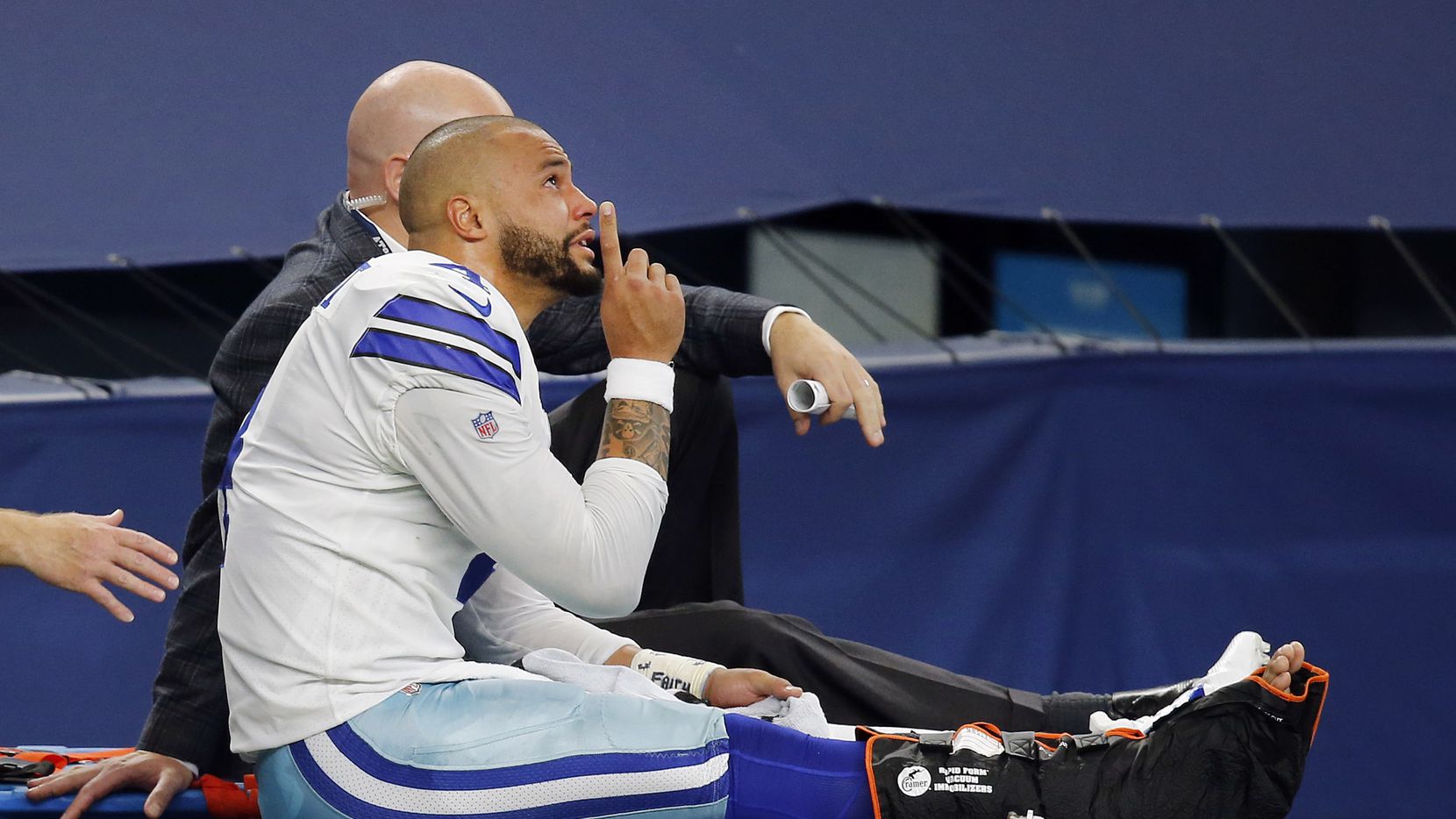 With tears in his eyes, Dallas Cowboys quarterback Dak Prescott (4) points skyward as he is carted off the field after sustaining a leg injury in the third quarter at AT&T Stadium Stadium in Arlington, Texas, Sunday, October 11, 2020. The Cowboys are facing the New York Giants.