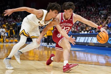 Indiana guard Trey Galloway (32) and Wyoming's Brendan Wenzel (5) fight for a loose ball...