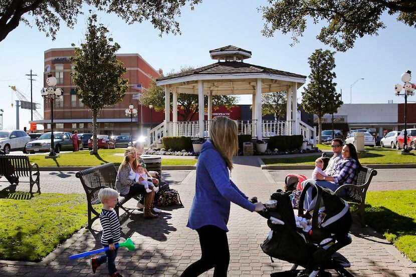 Families with young children and babies stroll through historic downtown Carrollton.