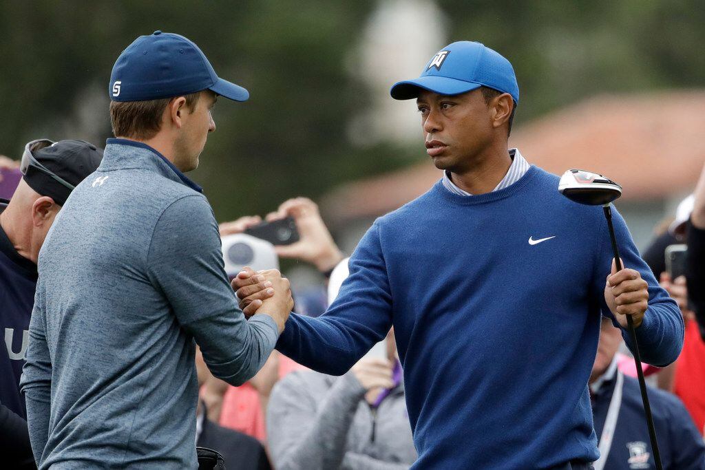 Jordan Spieth, left, and Tiger Woods shake hands on the 10th hole during the second round of...