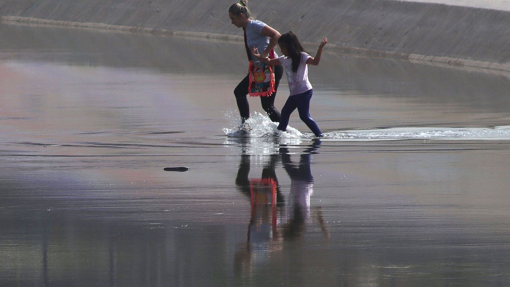 A woman and a child from Venezuela cross the Rio Grande from Ciudad Juárez, Mexico into El...