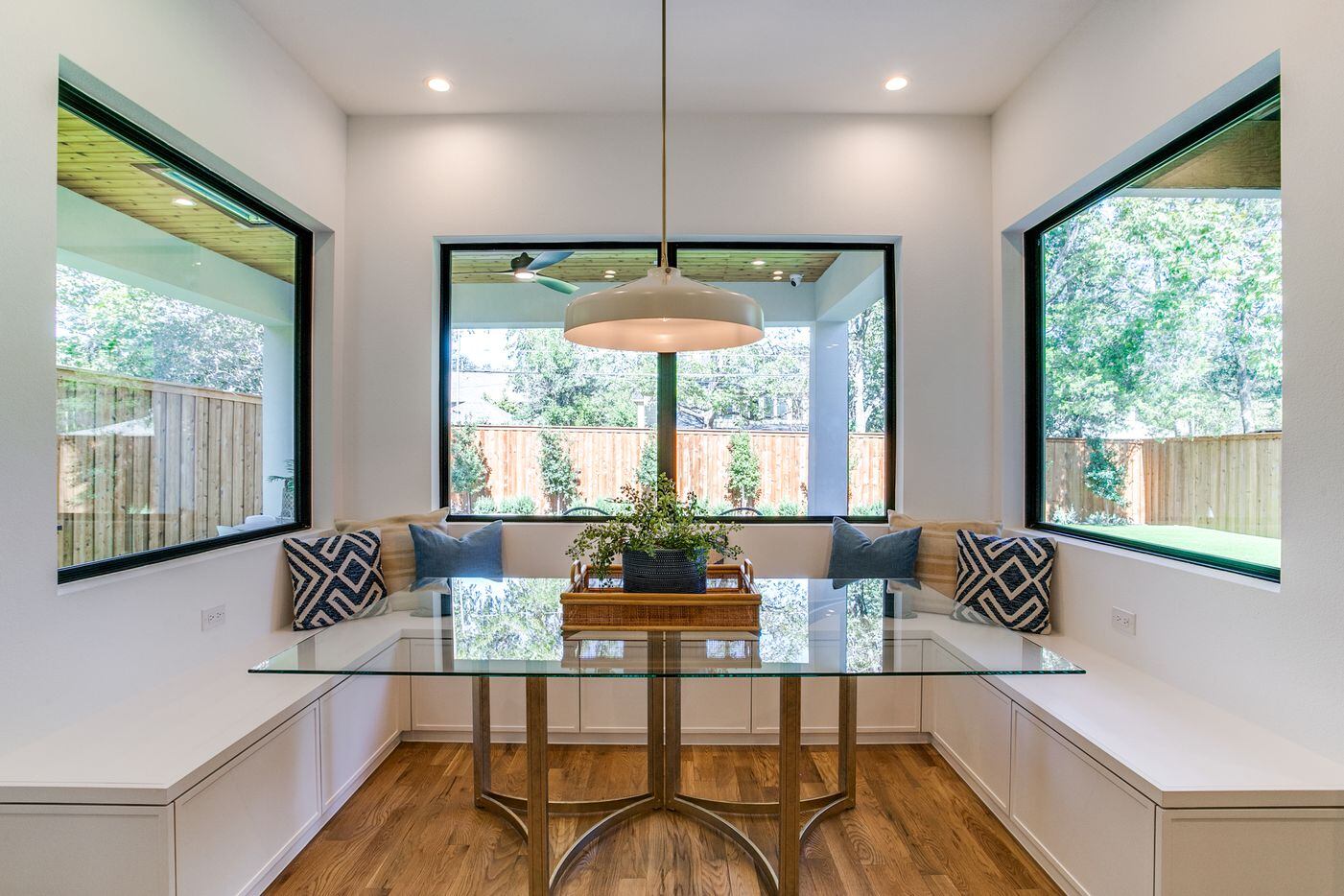 The breakfast nook features a glass table and built-in seating.
