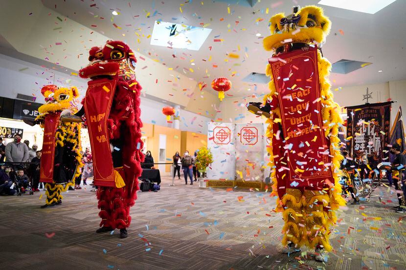 Confetti flies as members of the Jiu Long Sports Association Lion Dance Troupe perform...