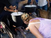 Migrants prepare meals to share with other migrants at Plaza de la República, a public...