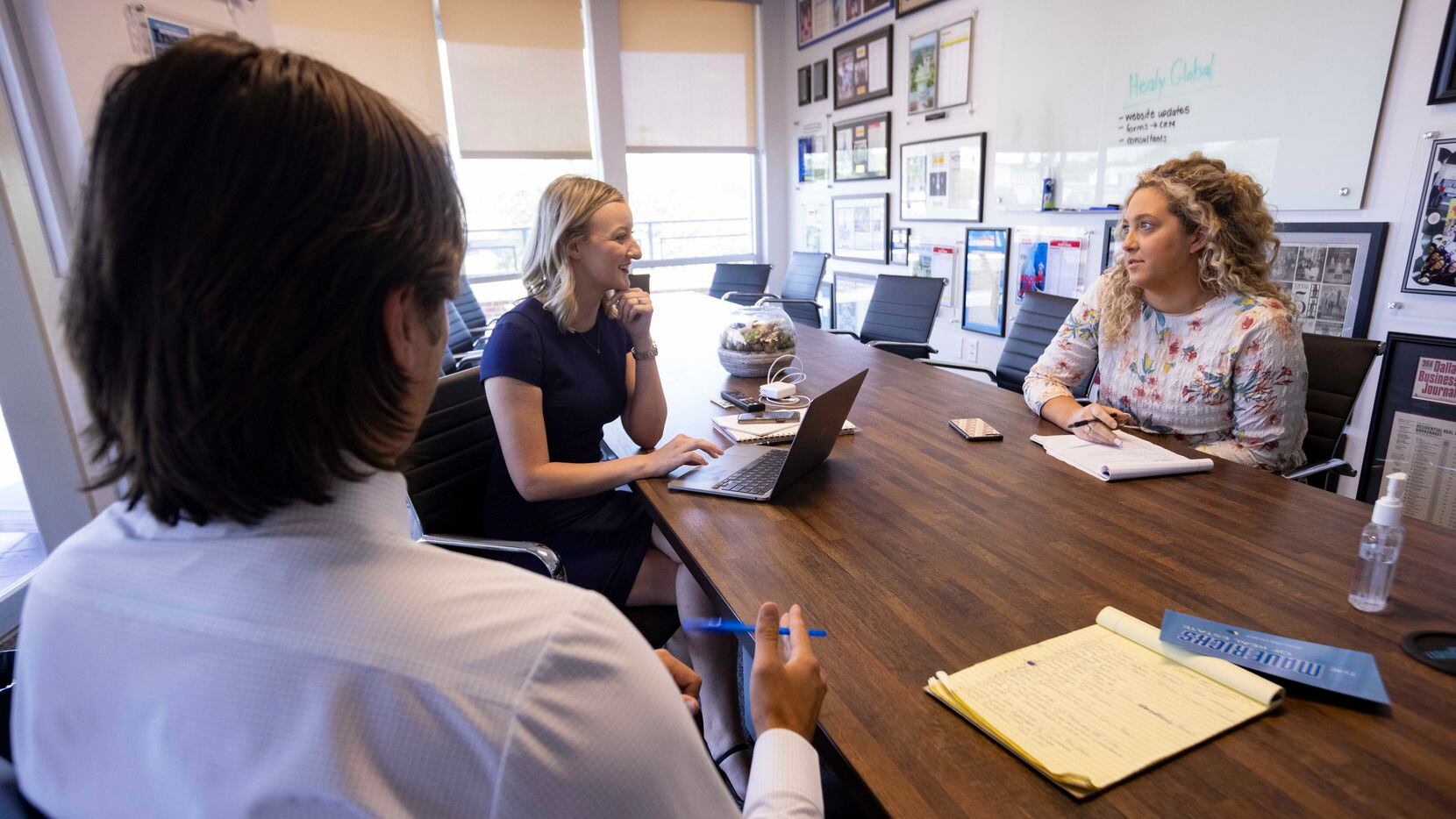 From left: Client relationship coordinators Michael Salerno and Molly Evans meet with graphic designer Maddie Hess at the Rogers Healy and Associates office in Dallas.
