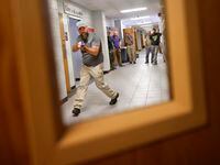 Henderson County Sheriff’s Deputy Kenneth Slatonapproaches an open classroom door as they...