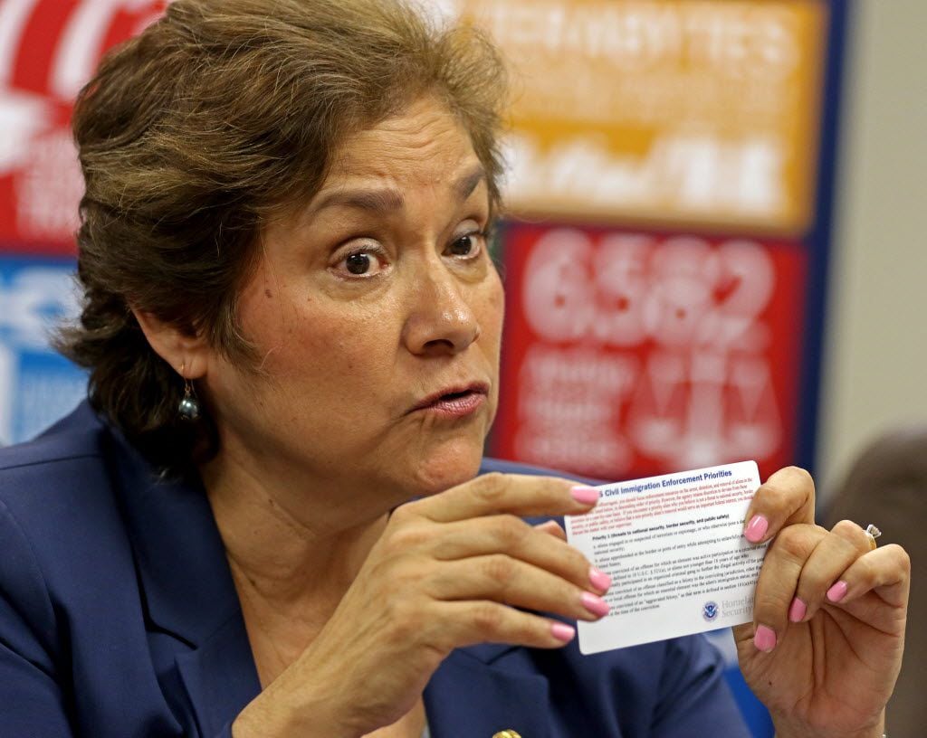 Saldana holds a card that lists ICE's old "civil immigration enforcement priorities." The...