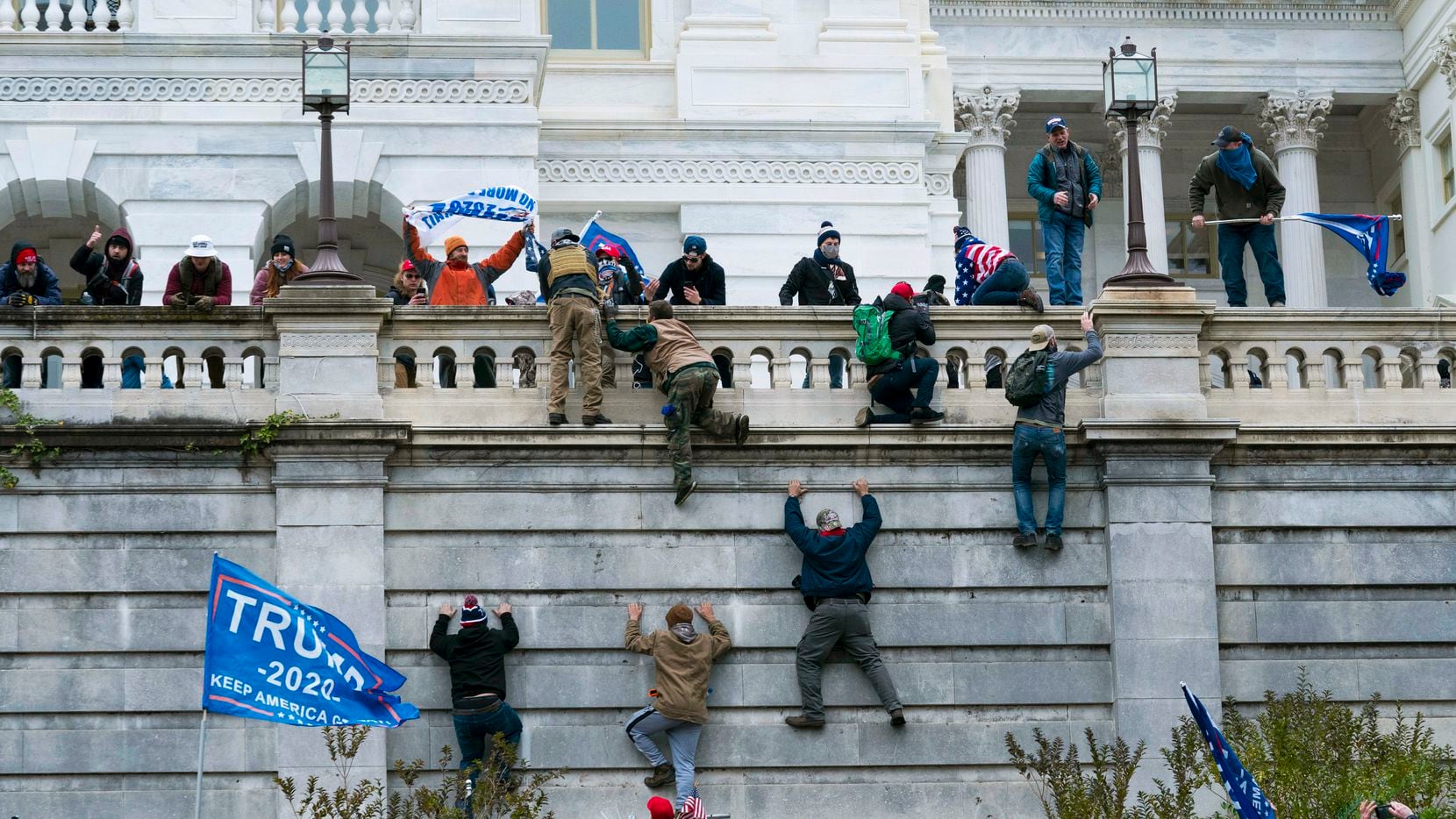 Supporters of President Donald Trump climb the west wall of the the U.S. Capitol in Washington as they try to storm the building on Jan. 6, 2021, while inside Congress prepared to affirm President-elect Joe Biden's election victory.