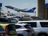 A Silk Way West Airlines cargo plane takes off over cars parked in the Express South lot at...