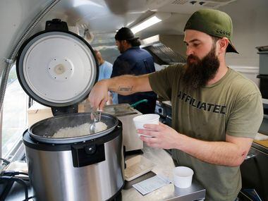 Jep Robertson fills an order for a customer in his food truck "Jep's Southern Roots," at...