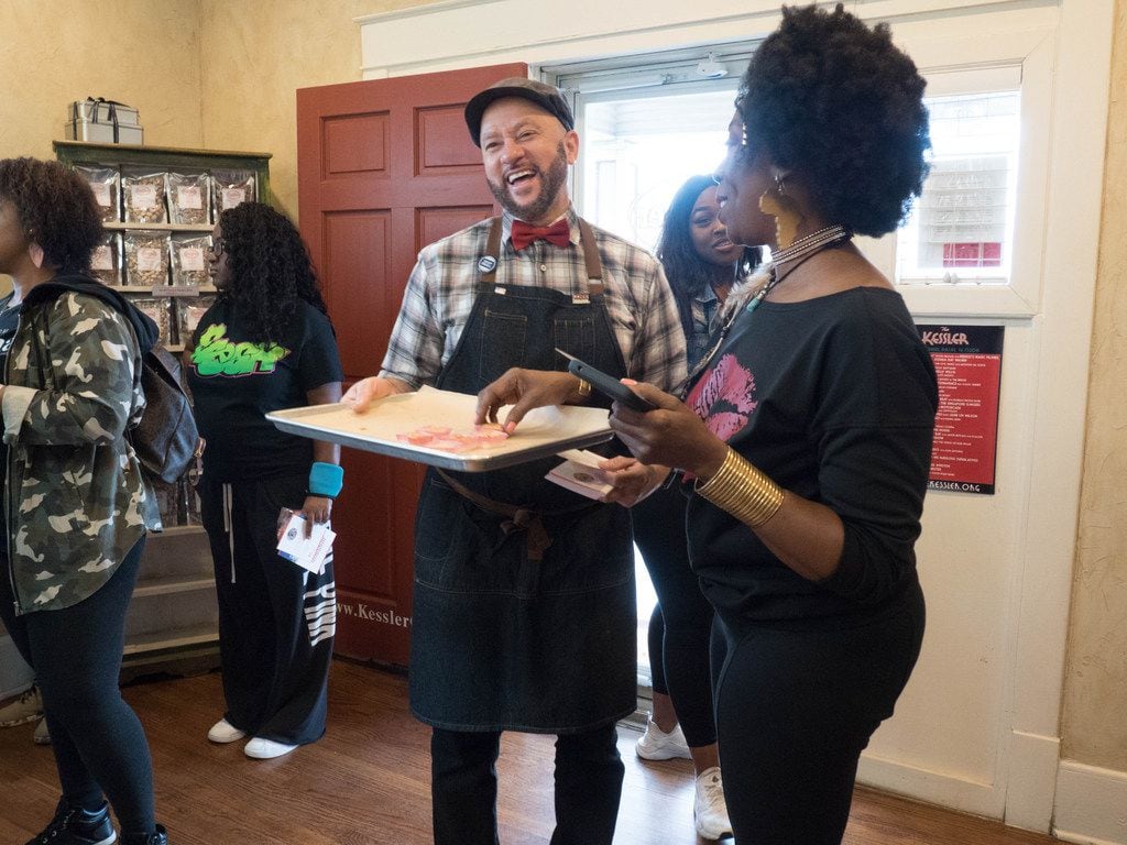 Clyde Greenhouse, owner of Kessler Baking Studio (center) hands out samples to attendees of...