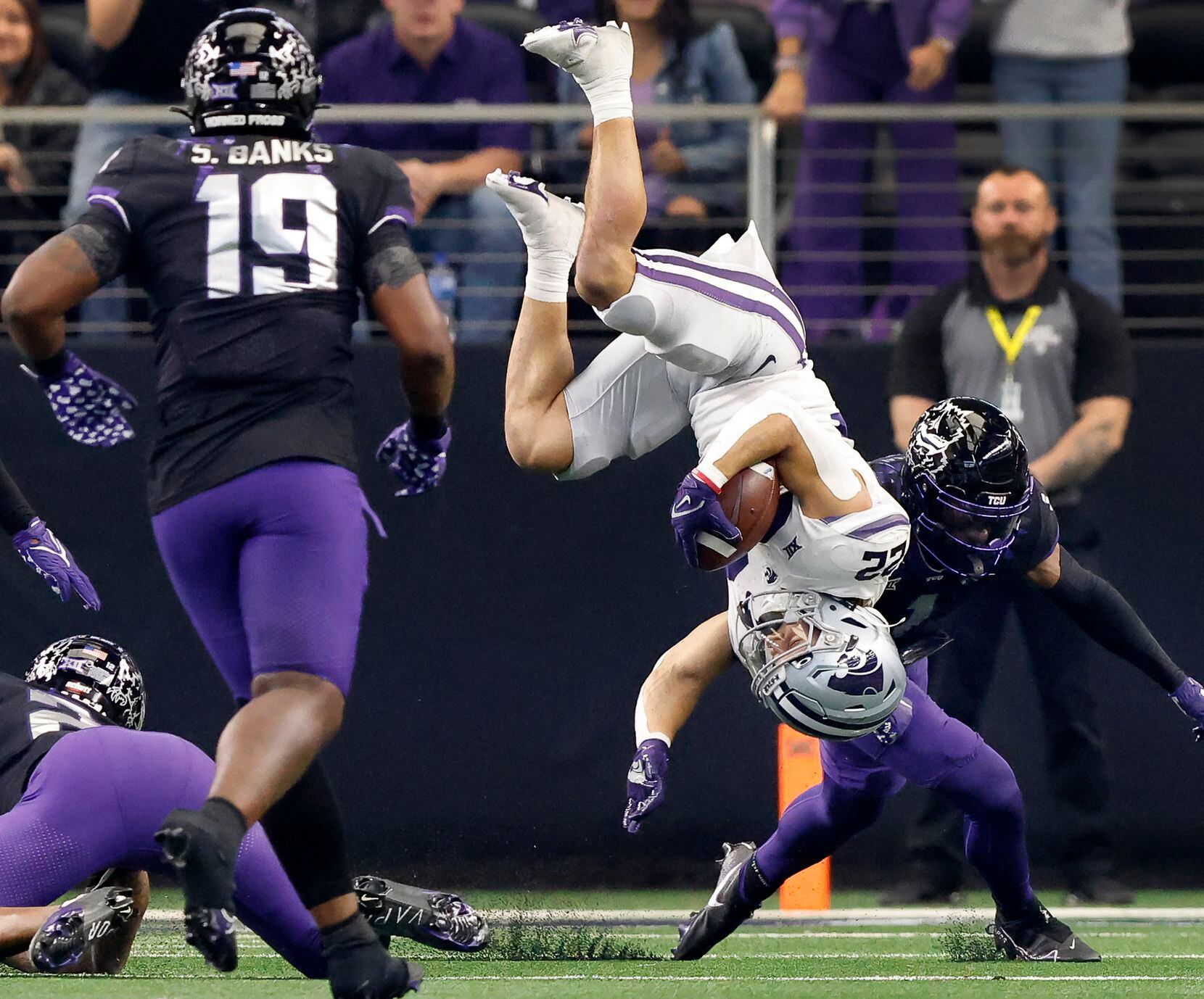 Kansas State Wildcats running back Deuce Vaughn (22) is flipped over after having his legs...