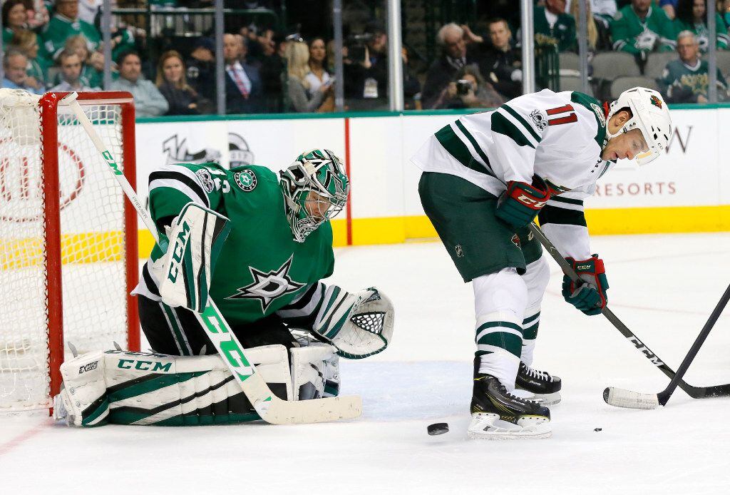 Minnesota Wild's Zach Parise (11) clears a path for a shot by a teammate as Dallas Stars'...