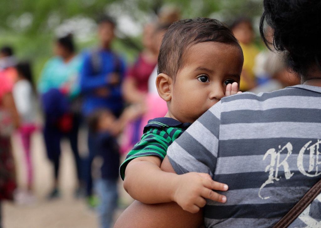  Lian Mejia Ruiz, 7 months, peered over the shoulder of his mother, Carmen Mejia, earlier...