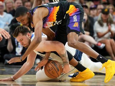 Dallas Mavericks guard Luka Doncic (77) fights for a loose ball against Phoenix Suns forward...