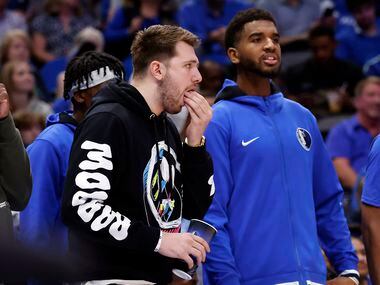 Dallas Mavericks guard Luka Doncic eats a snack on the sideline as he watches Game 1 of an...